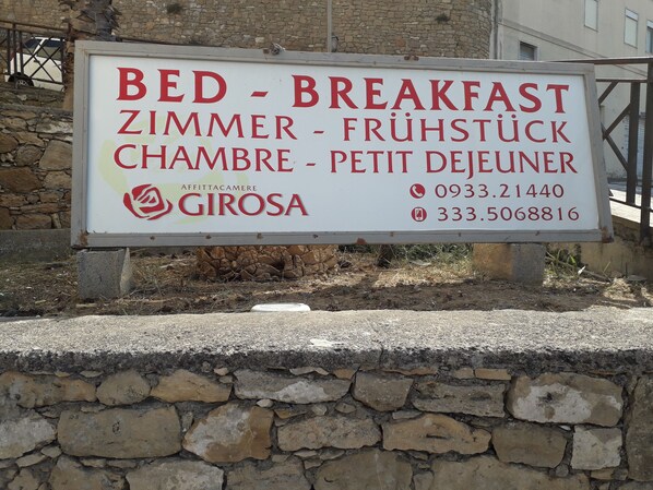 A sign for a bed and breakfast with contact numbers.