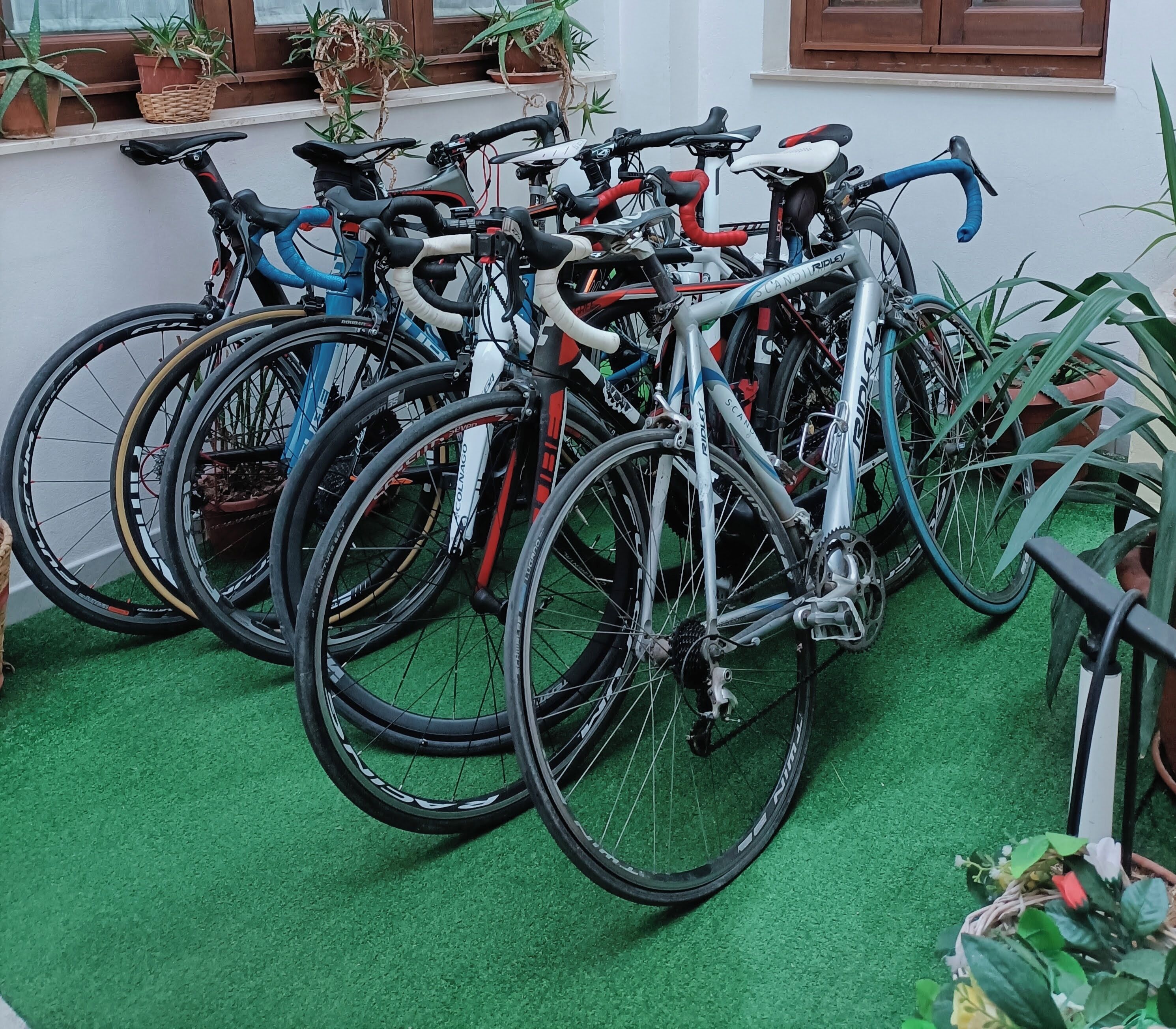 Cykelparkering indendørs med kunstgræs og plantekasser.