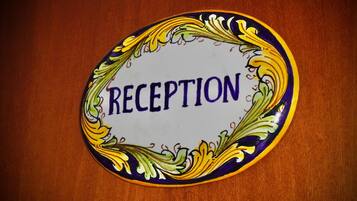Señal de recepción con motivos florales decorativos y la palabra 'RECEPTION' en el centro.