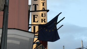 Un letrero de hotel con la leyenda 'YASHA HOTEL RESTAURANT' y una bandera.