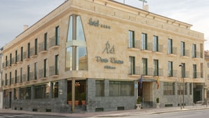 A hotel with a large sign reading "Hotel Puente Romano" and a balcony with a flag. - Hotel Ele Puente Romano (Salamanca)