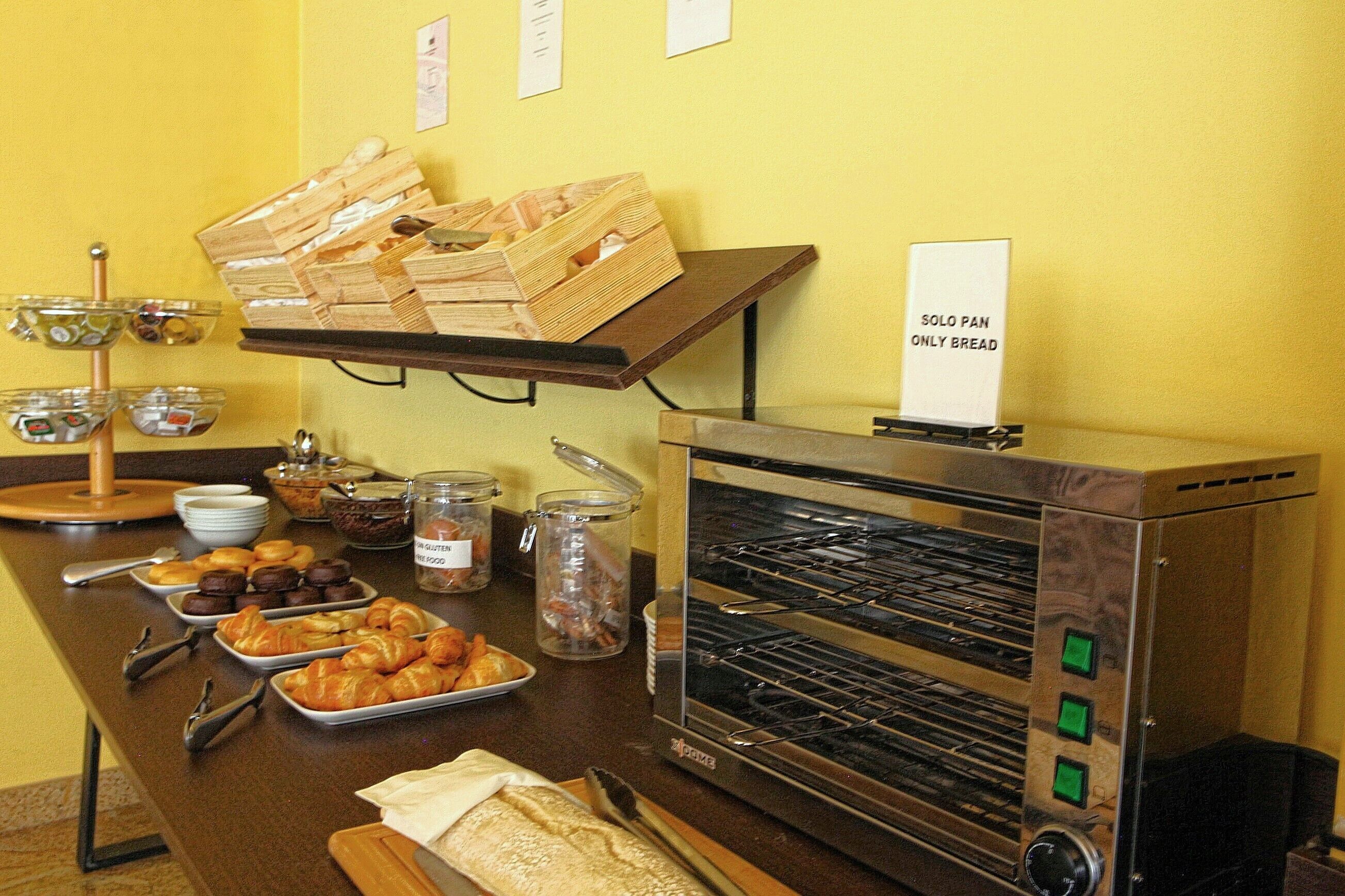A buffet setup with various food items, a bread display, and a bread oven.