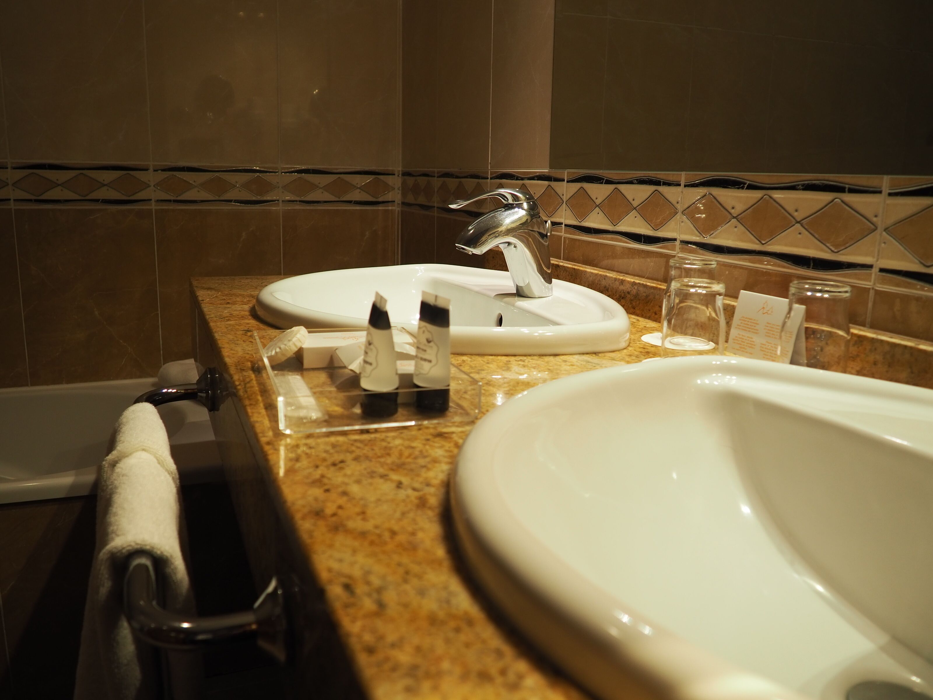 Un bagno con lavandino, specchio e portasciugamani.
