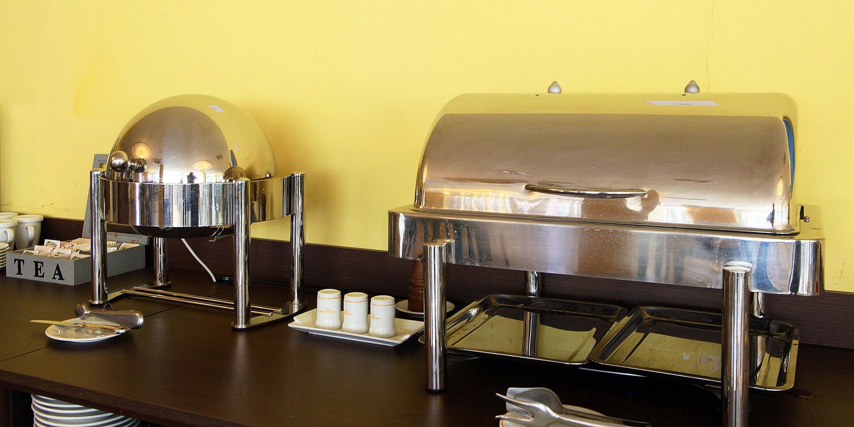 A buffet setup with a coffee machine, tea station, and a grill station.