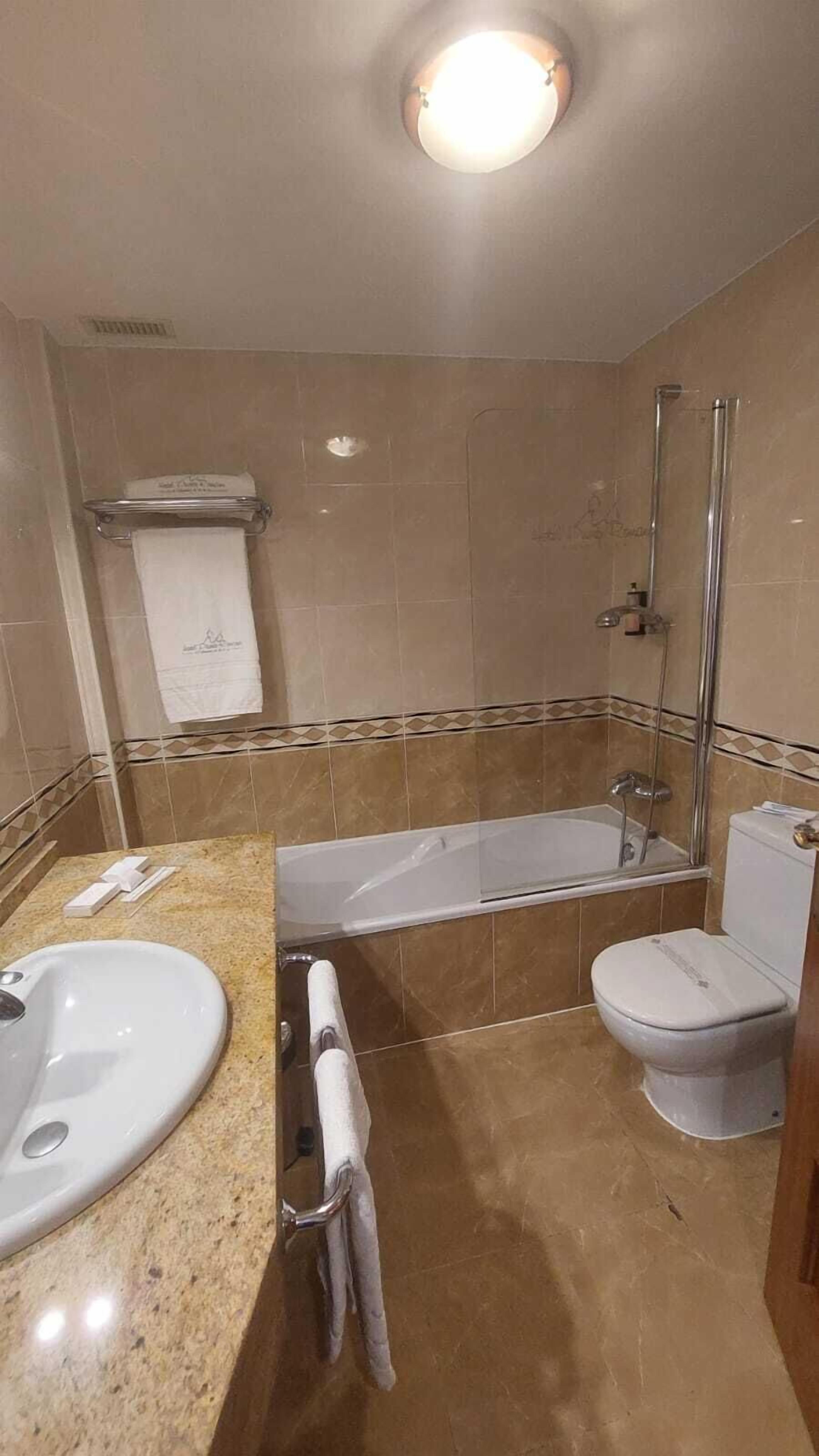 A bathroom with a bathtub, toilet, and sink.