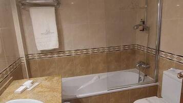A bathroom with a bathtub, toilet, and sink.