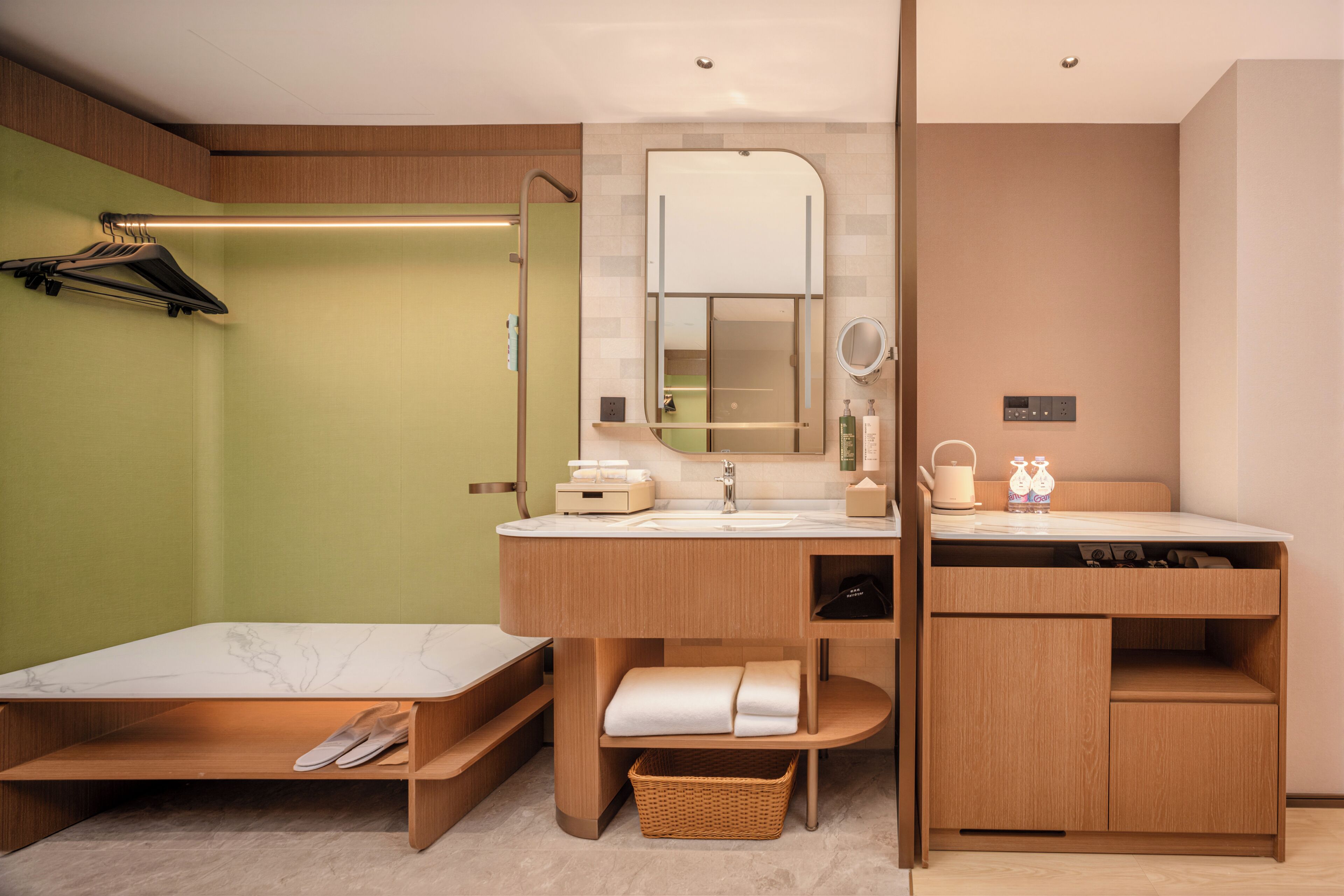 Un baño moderno con tocador de madera, un espejo grande, toallero y un lavamanos pequeño.