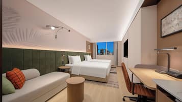 Una moderna camera d'albergo con un letto, una poltrona, una scrivania e una sedia.
