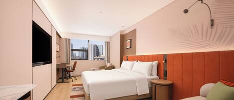 Ein Hotelzimmer mit Bett, Schreibtisch, Stuhl, kleinem Tisch, Fernseher und Fenster mit Stadtblick.