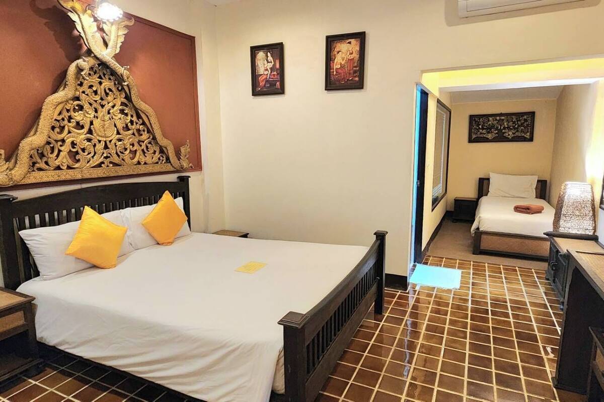 A hotel room with a bed, a nightstand, a lamp, and a decorative wall piece.