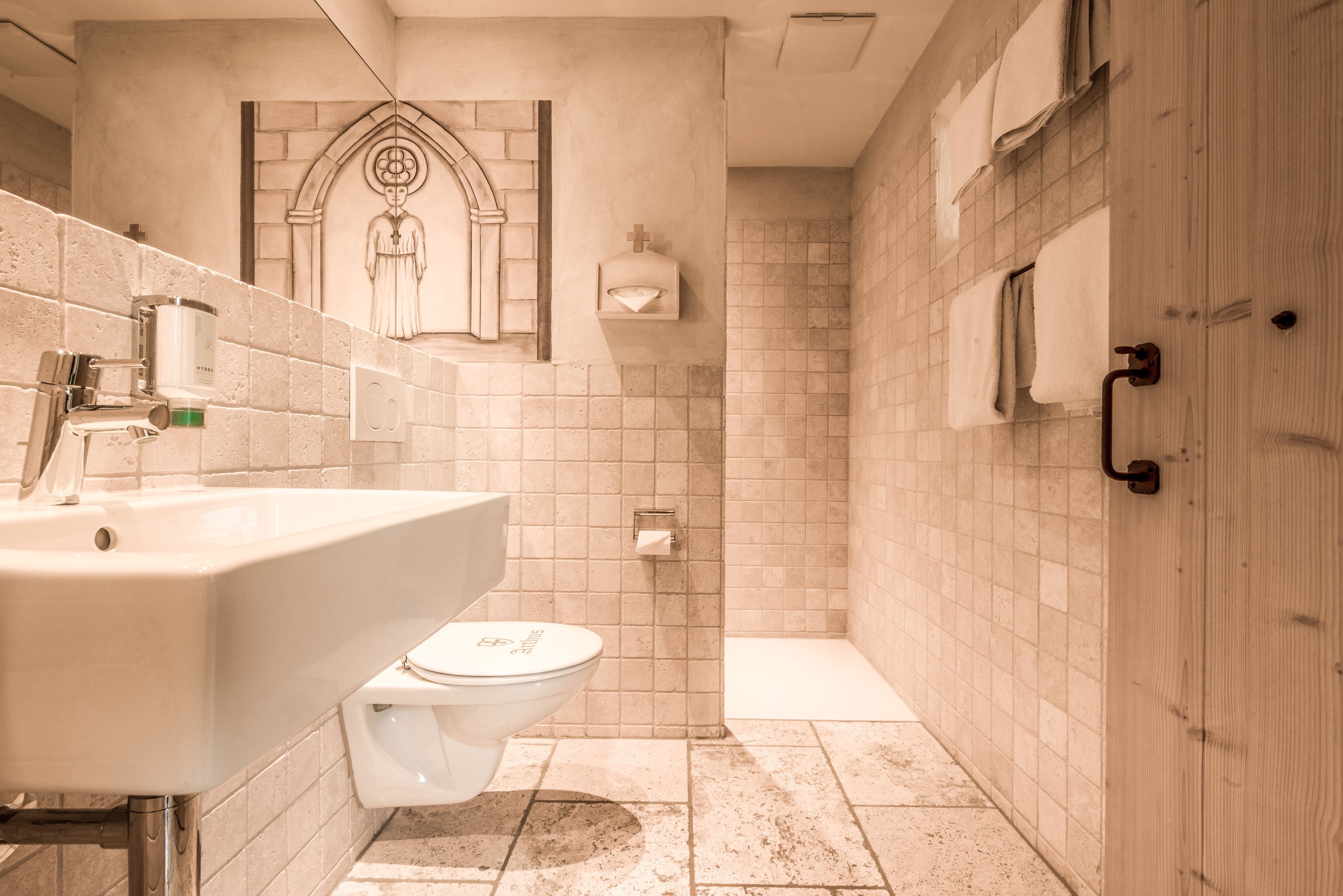 A bathroom with a sink, toilet, and shower area.