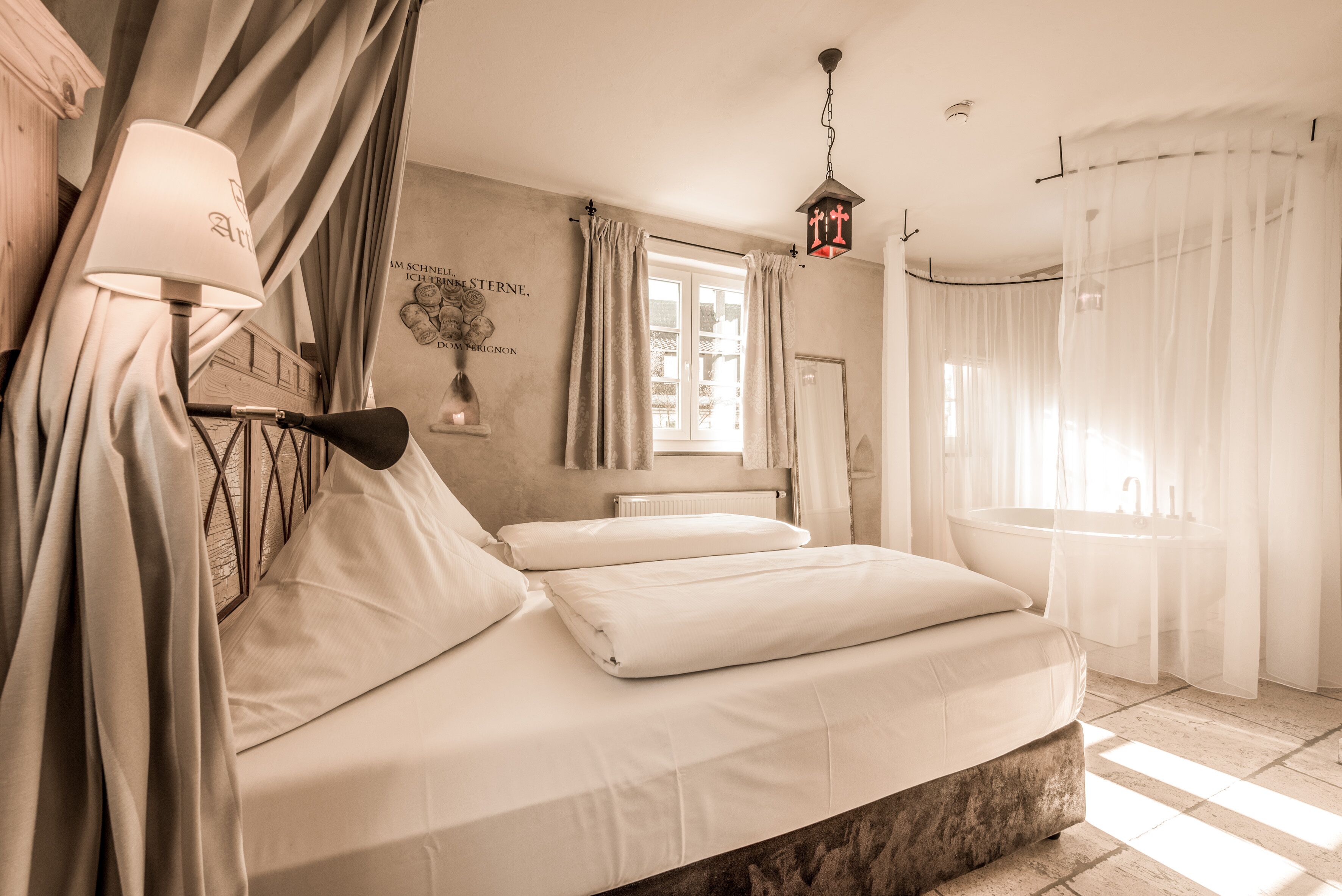 A bedroom with a bed, a window, a bathroom with a bathtub, and a wall with a decorative item.