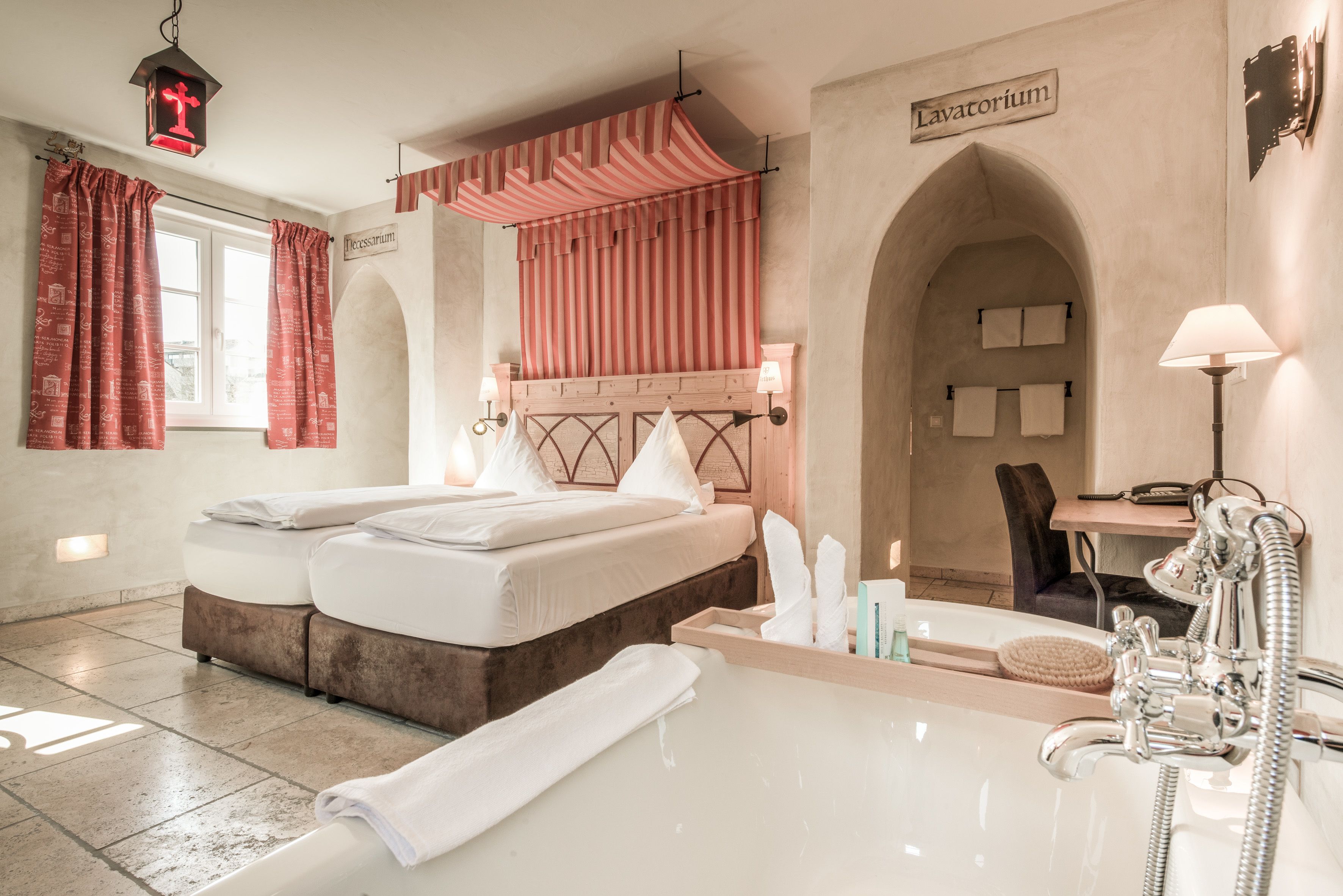 Una habitación de hotel con una cama doble, una bañera, un tocador con espejo y una ducha.