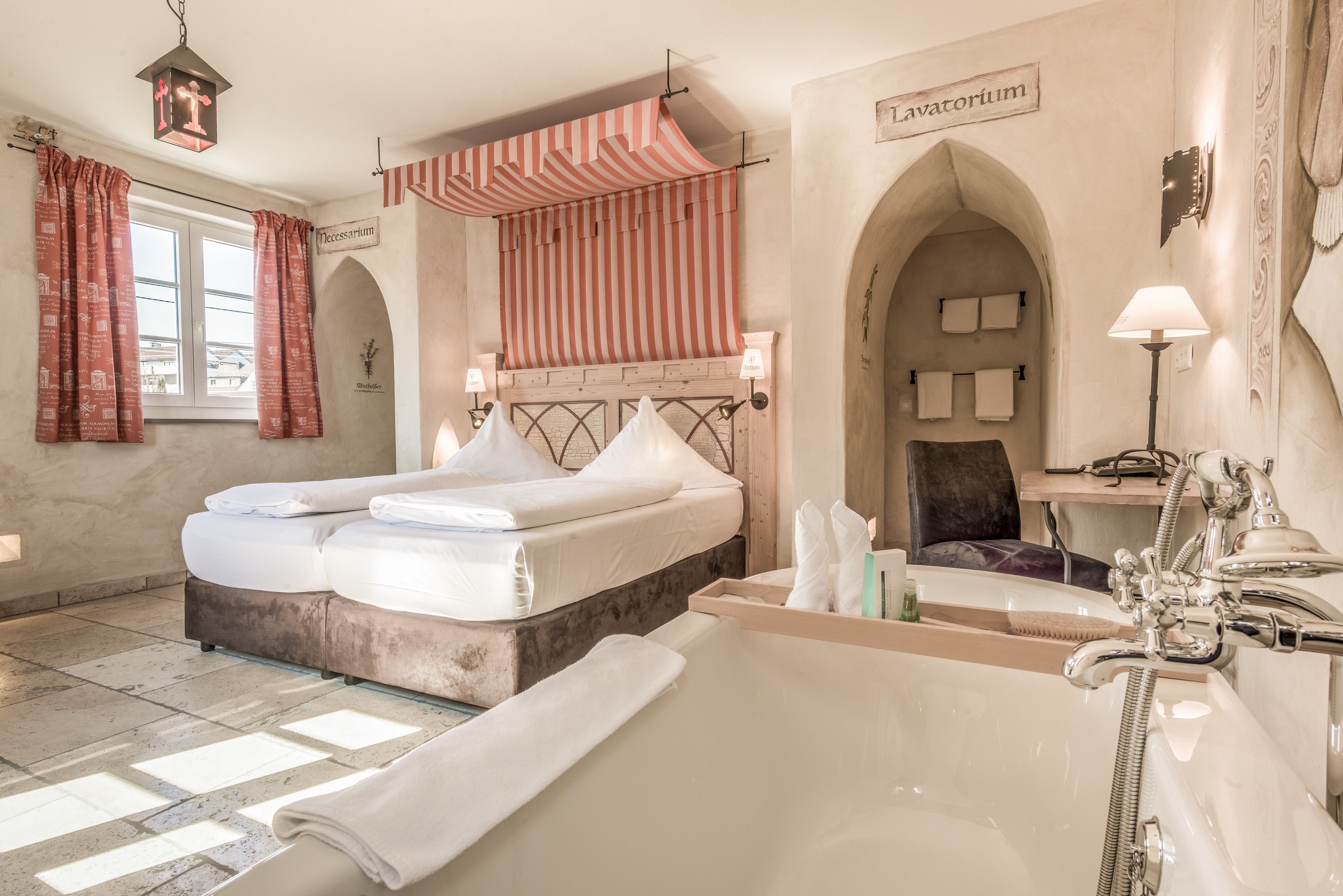 A hotel room with a large bed, a bathtub, and a shower. There are two towels on the bed and a towel on the floor.
