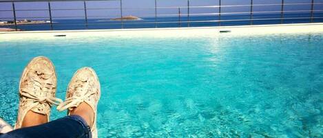 Una piscina al aire libre de temporada, sillones reclinables de piscina
