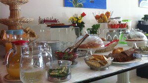 Uma mesa de buffet com diversos alimentos e bebidas.