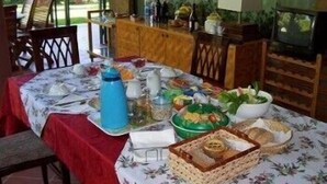 A dining table set with various dishes and a blue water bottle, surrounded by chairs and a wooden cabinet with kitchenware. - Bellavista Country House (Pescara)