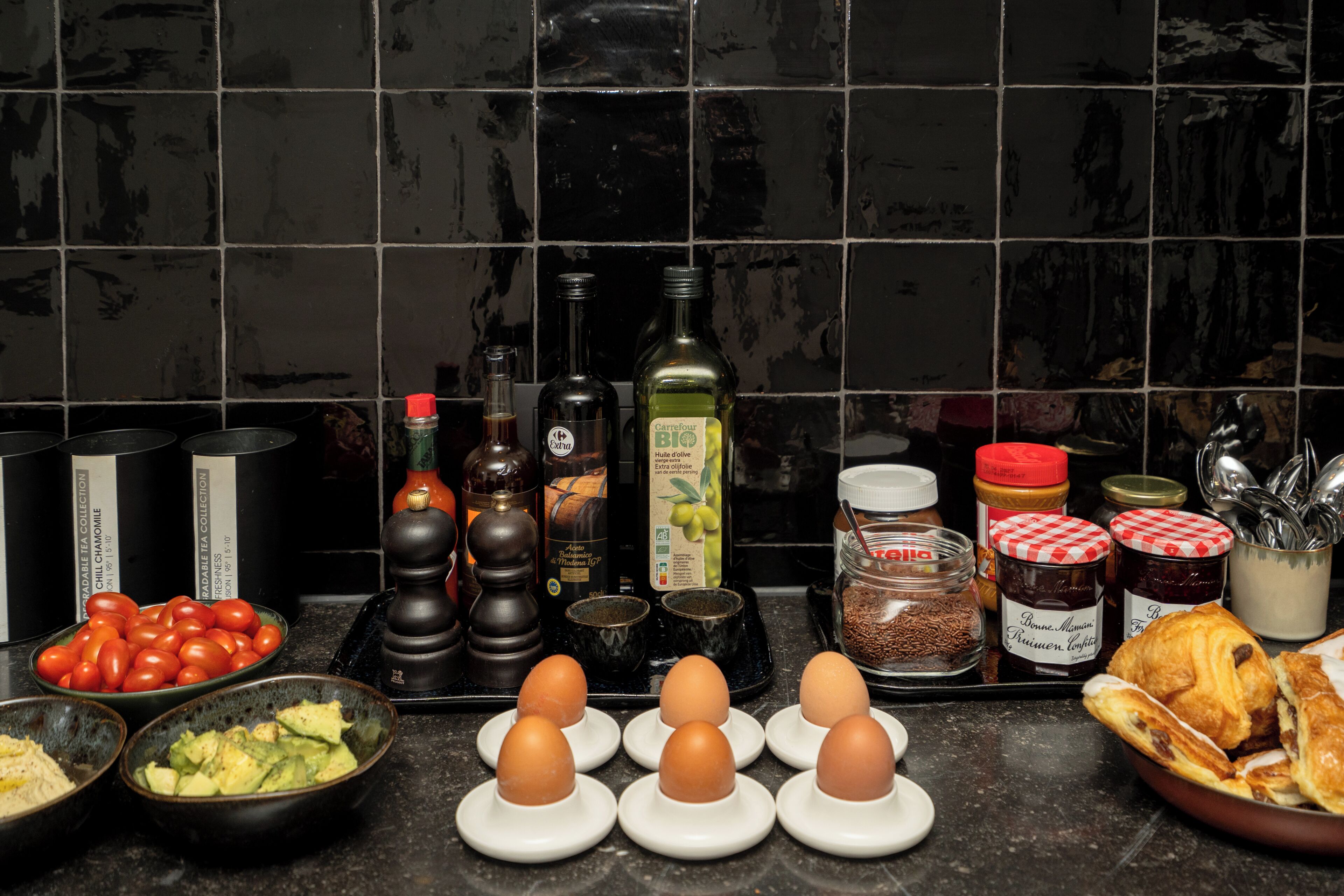 Un plan de travail de cuisine avec divers aliments, notamment des tomates, des œufs et du pain.