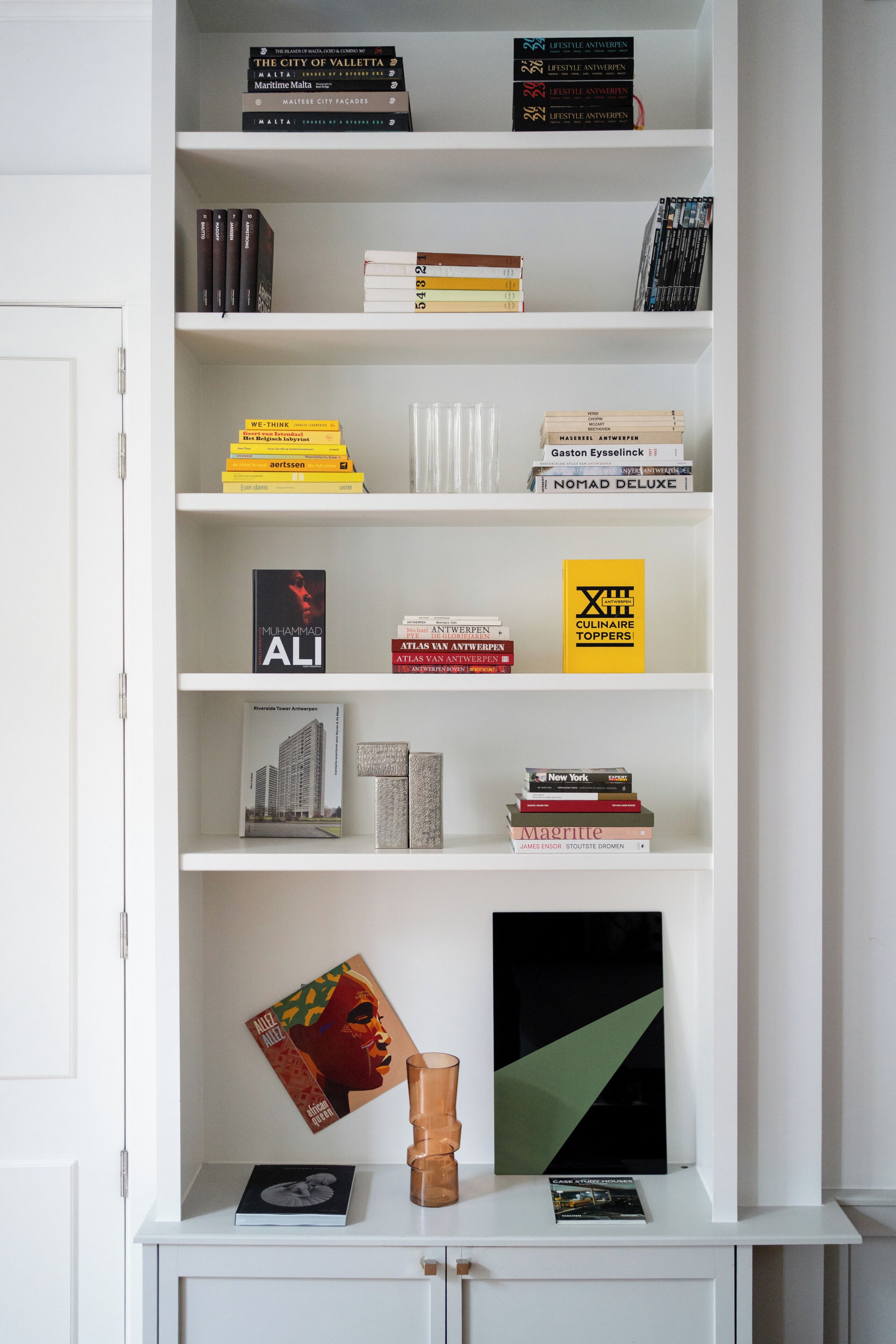 Une bibliothèque contenant divers livres et objets décoratifs.