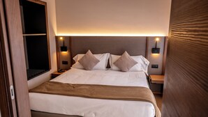 A modern hotel room with a large bed, two bedside tables, and a nightstand. -  Residence Porta al Prato (Florence)