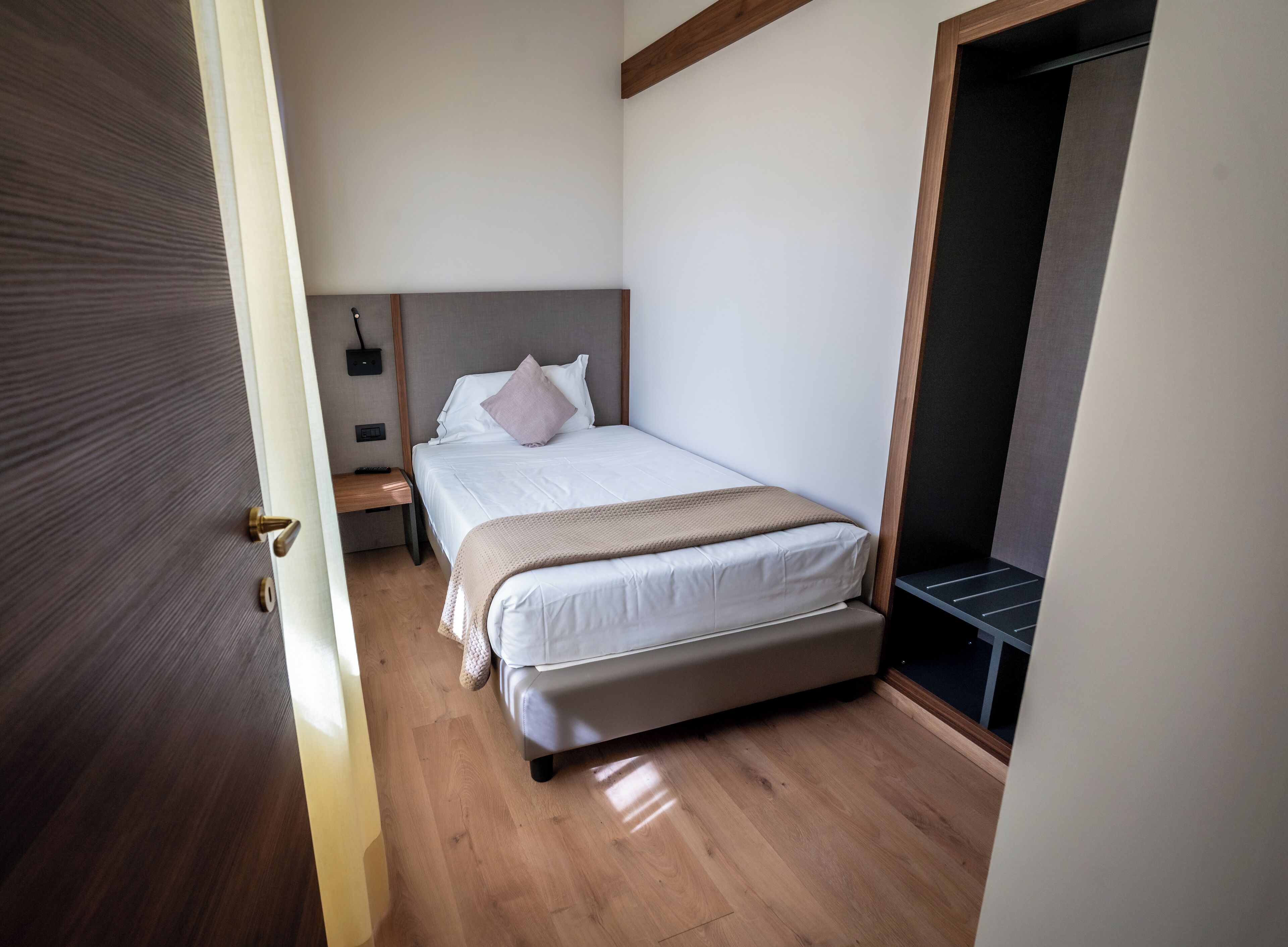 Ein Schlafzimmer mit Bett, Nachttisch und Kleiderschrank.