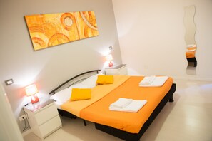 Une chambre d’hôtel moderne, équipée d’un lit, de tables de chevet et d’un tableau au mur.