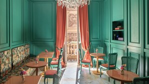 A room with teal walls, a chandelier, a patterned sofa, and a view through a doorway. - Hotel City Palazzo dei Cardinali (Rome)