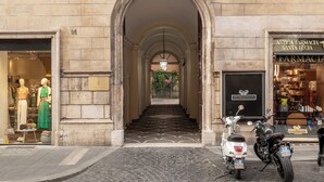 A building with a stone facade, a central archway, and a sign for 'ANTICA FARMAGIA SANTA LUCIA.' - Hotel City Palazzo dei Cardinali (Rome)