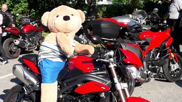 En röd motorcykel med en stor nallebjörn sittande på den.