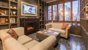 A cozy living room with a fireplace, comfortable sofas, and a coffee table with magazines.