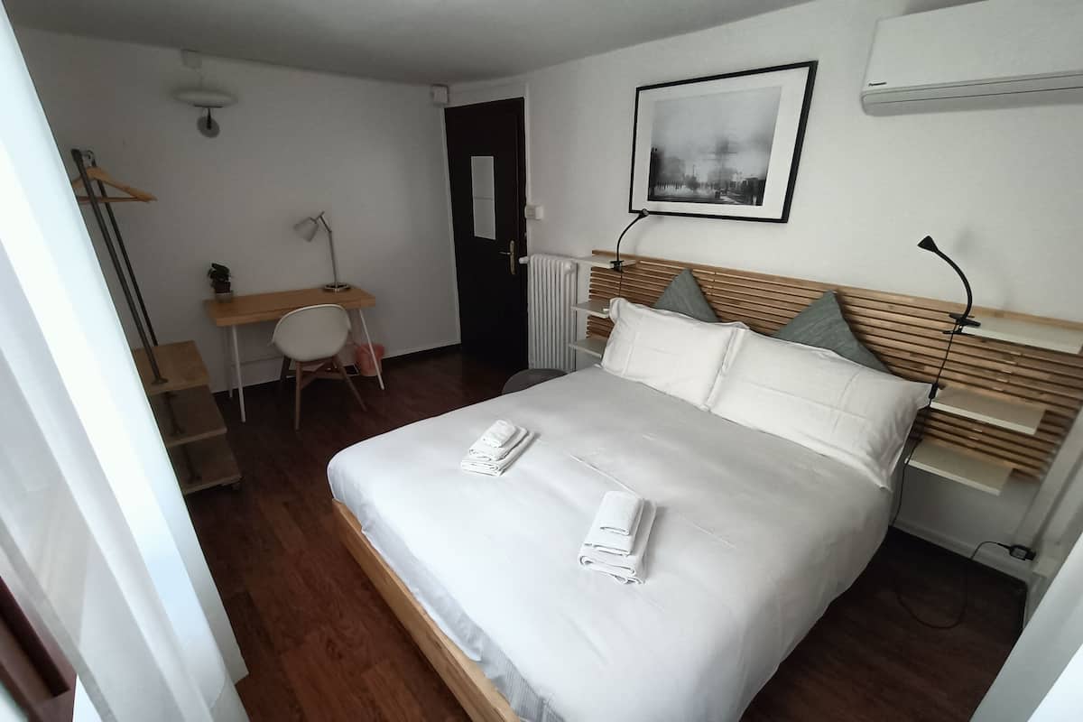 Een keurig opgeruimde hotelkamer met een bed, een bureau en een stoel.