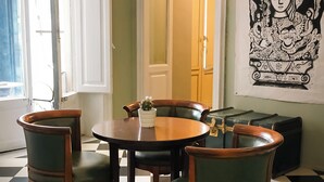 Een eethoek met een zwart-wit geruite vloer, een ronde tafel en vier stoelen.