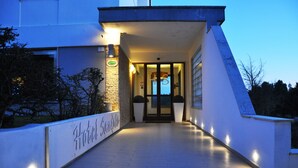 A hotel entrance with a modern design, a covered walkway, and a sign indicating the name 'Hotel Sandalina'. - Hotel Sandalia (Nuoro)
