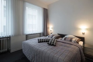 Driepersoonskamer | Een strijkplank/strijkijzer, beddengoed