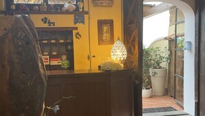 Un espace d’accueil avec un comptoir en bois, une lampe décorative et une grande fenêtre donnant sur l’extérieur.