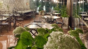 Un espace de restauration intérieur doté de poutres en bois au plafond, de murs en pierre et de nombreuses tables et chaises.
