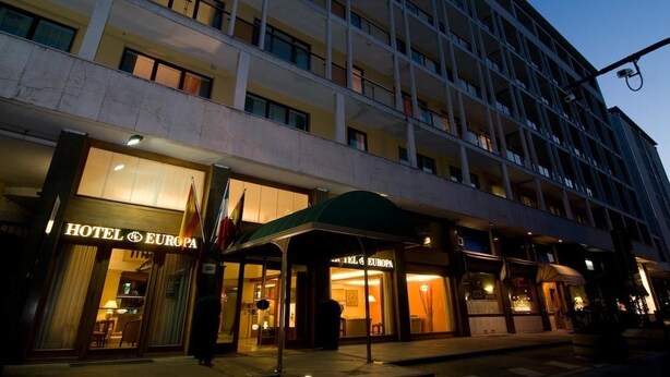 Un hotel de varios pisos con una entrada destacada y un espacio exterior cubierto.