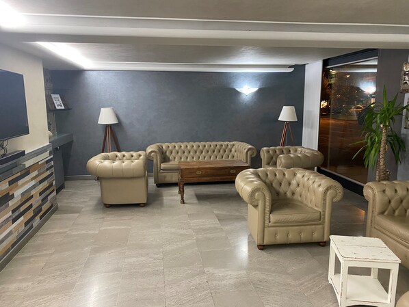 Una sala de estar moderna con un conjunto de sofá, una mesita de centro y una mesita auxiliar.