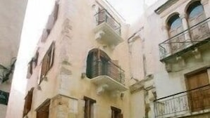 A courtyard with a stone floor, potted plants, and a wooden chair. - Ifigenia Rooms & Studios (Chania)