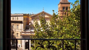 Vista di una chiesa con un campanile e un edificio con un balcone.