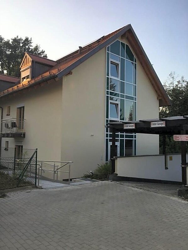 Un hotel con una amplia fachada de vidrio, un acceso cubierto y un balcón visible.