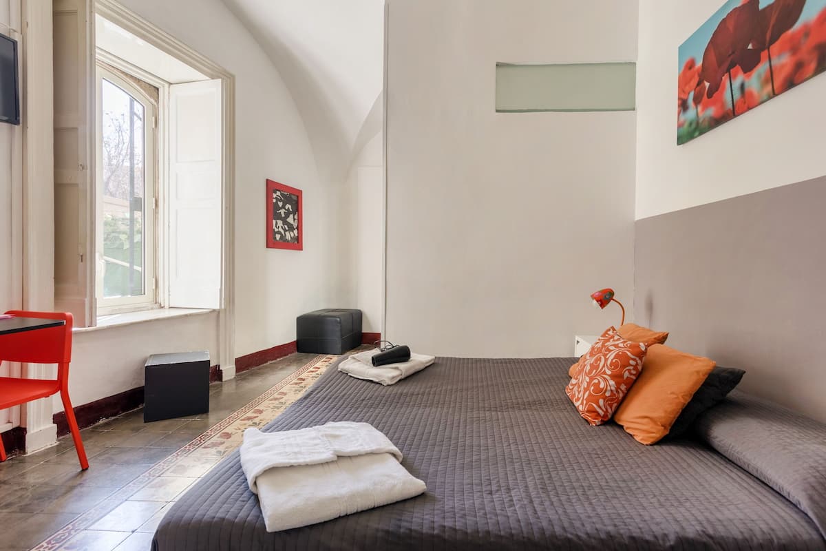 Une chambre d’hôtel avec un lit, un bureau et une chaise.