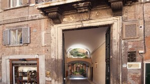 A building with a balcony, a shop on the ground floor, and flags of Italy and the EU. - Pantheon Inn (Rome)