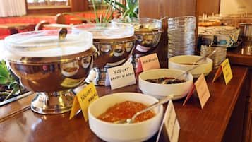 Un bufé con recipientes etiquetados de yogur, fruta y otros platos.