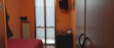 A room with a bed, a desk, a TV, and a wardrobe.
