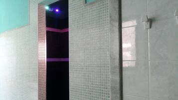 Simple, functional room with a tiled wall and door leading to a darker space.