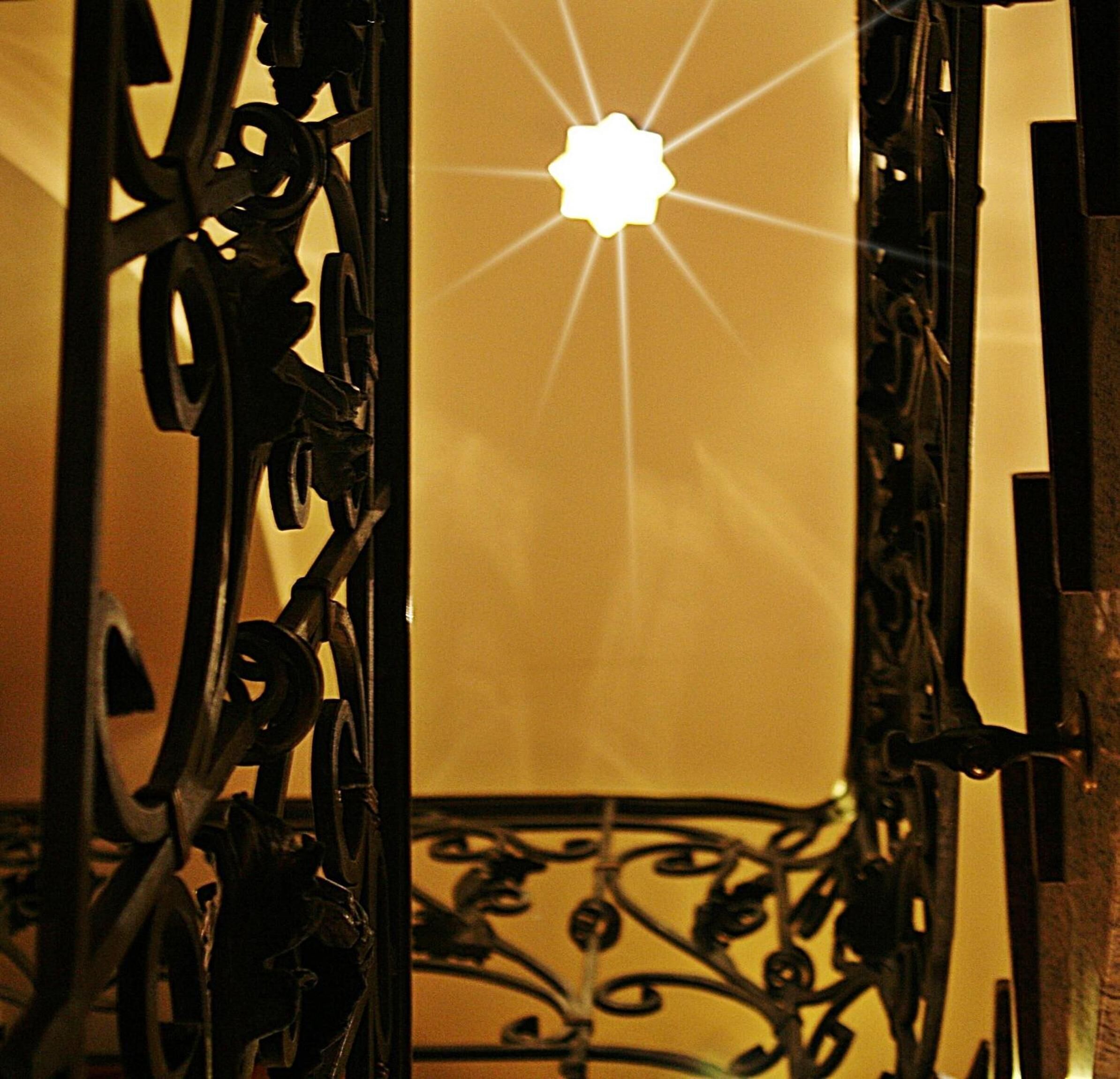 A wrought iron gate with a star-shaped light fixture in the center.