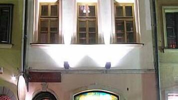 A multi-story building with a central entrance featuring a decorative archway and a sign above it.