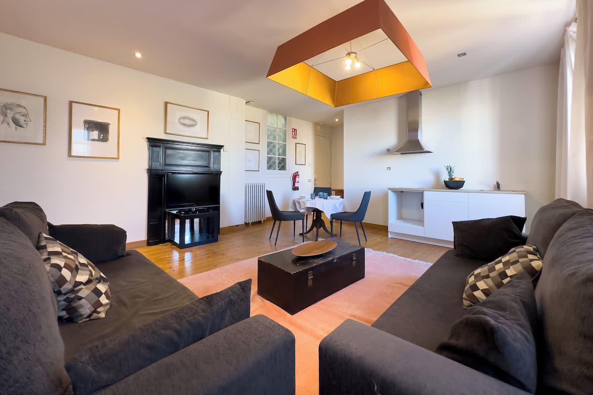 Una sala de estar moderna con chimenea, comedor y cocina.