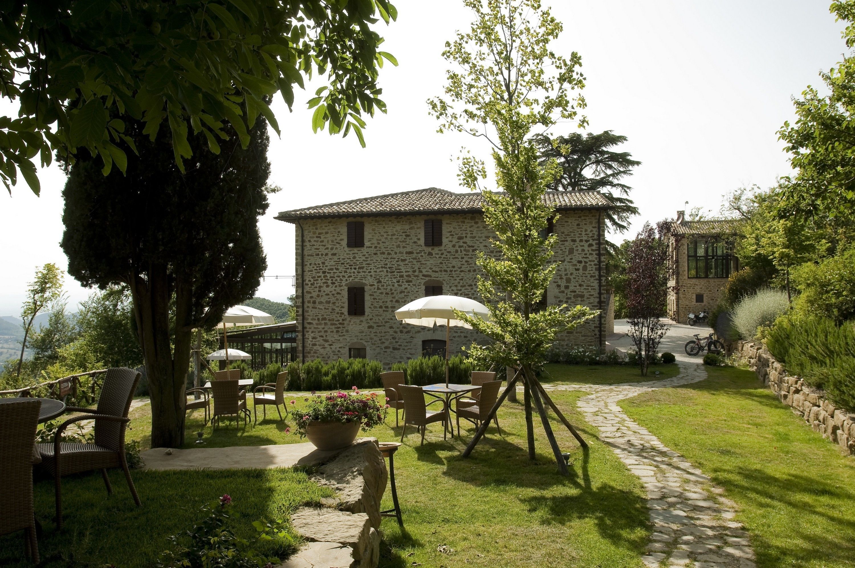 A stone building with a garden patio, outdoor seating, and a stone pathway.